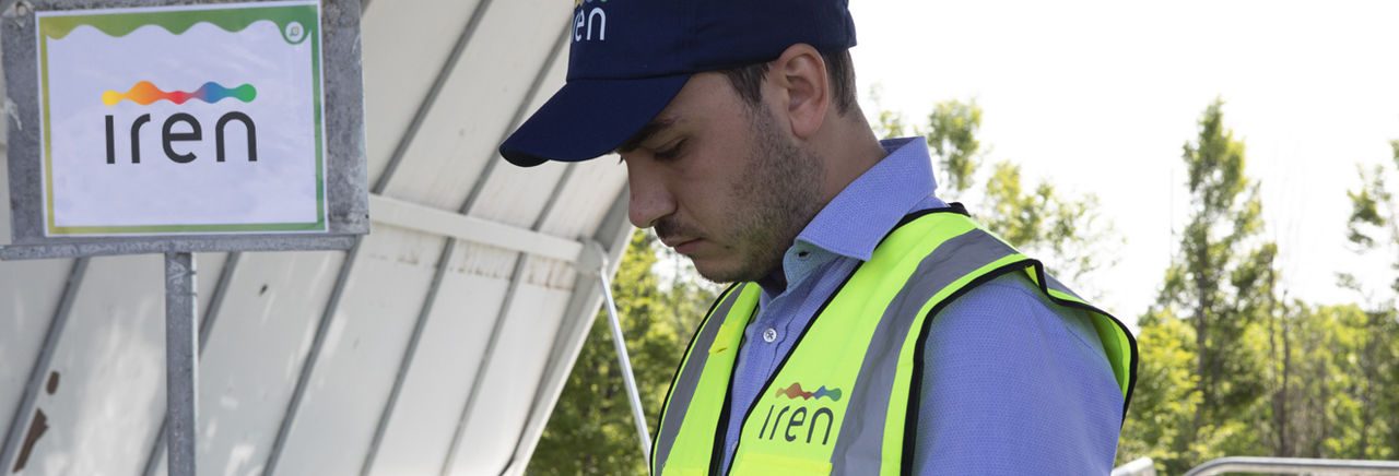 Dipendente Iren con il gilet di protezione che lavora con un tablet in una discarica